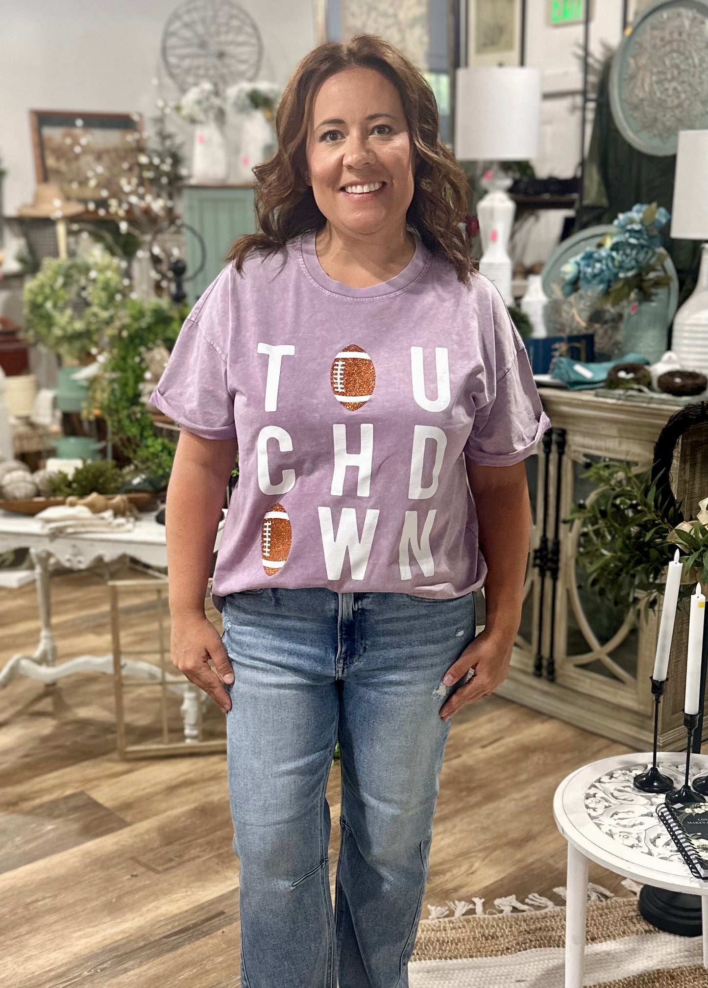 Woman wearing a purple t-shirt with 'Touchdown' text in a store setting